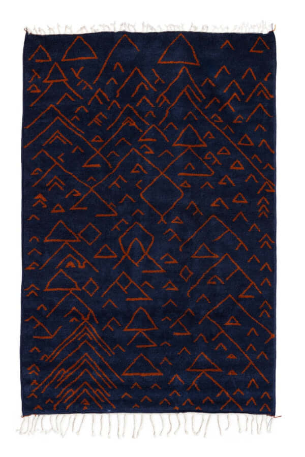 Amara Nuit - The mystique of Moroccan night rug featuring navy canvas with terracotta geometric patterns.