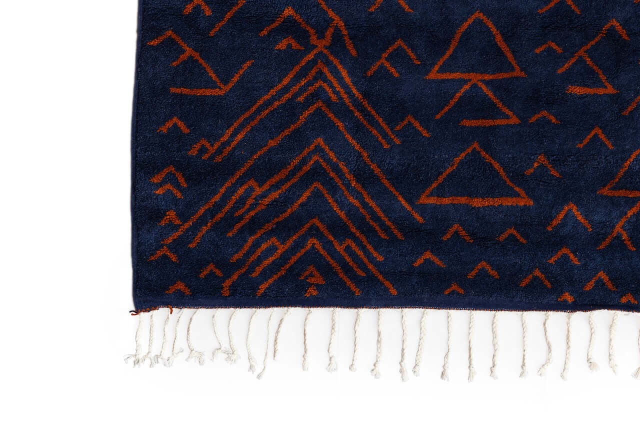 Amara Nuit - The mystique of Moroccan night rug featuring handwoven terracotta motifs on a navy background.