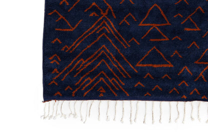 Amara Nuit - The mystique of Moroccan night rug featuring handwoven terracotta motifs on a navy background.