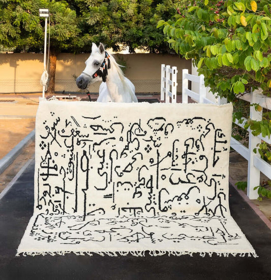 Love Carpet by Moe Khadra with Calligraphic Design displayed with a horse in a garden setting.
