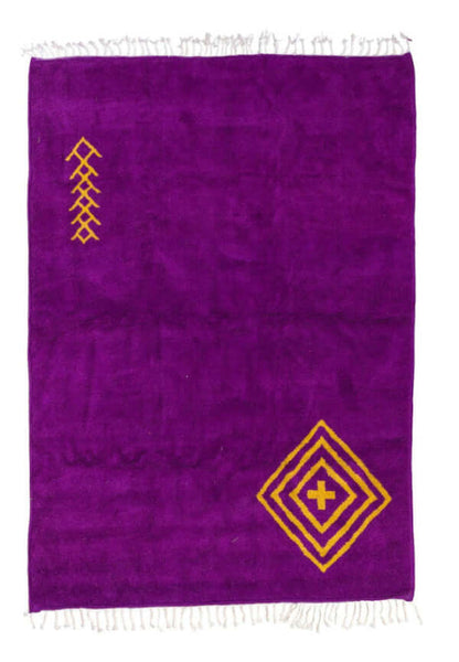 Sahara Gaze – Moroccan Rug with Golden Motifs featuring a deep magenta base and golden symbols.