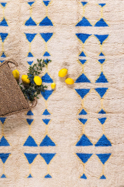 The Symbols by Fatima Rug – A Masterpiece of Craftsmanship with blue and yellow patterns on a neutral base.
