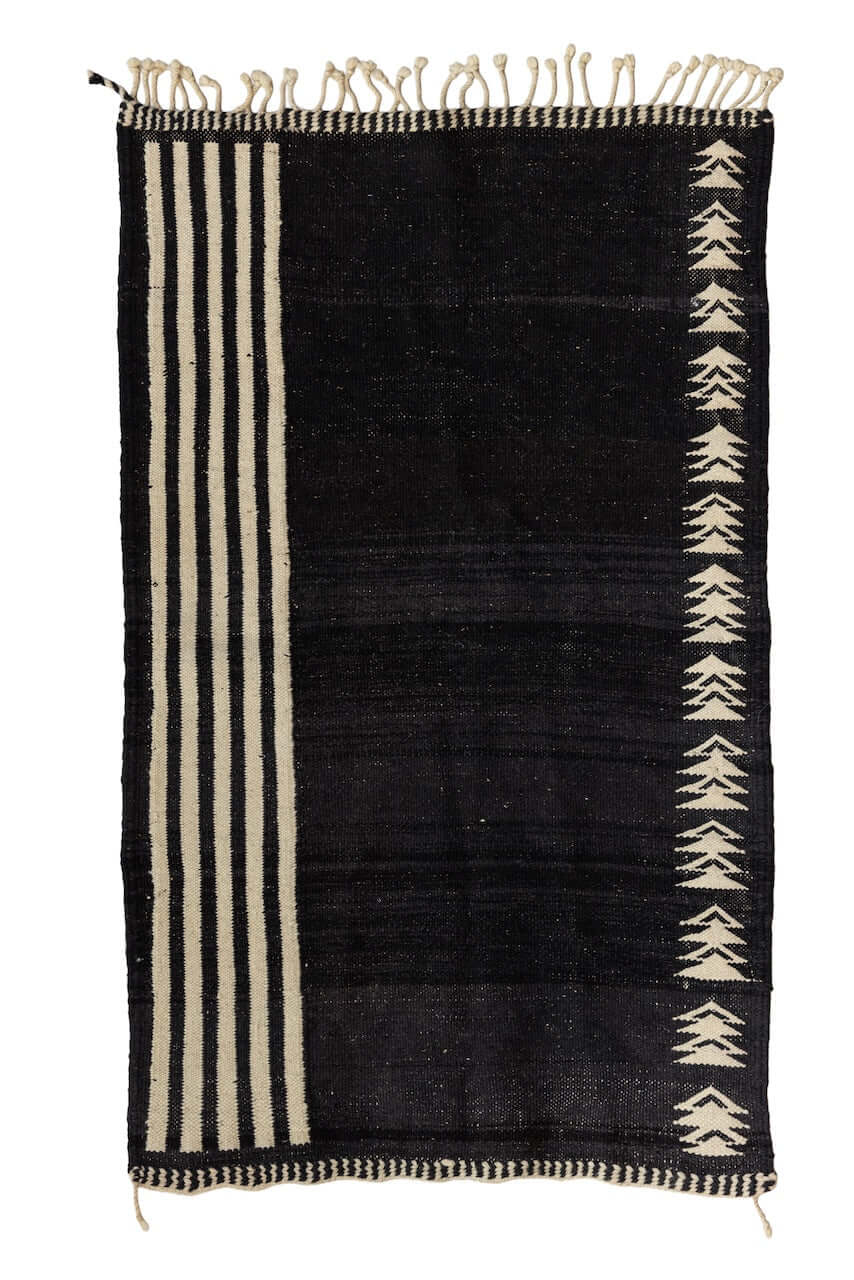 Char Noir – Black & Ivory Moroccan Rug showcasing a black field with ivory geometric patterns and linear borders.