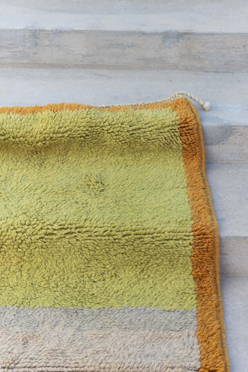 Kasbah Verde - Moroccan Rug with Geometric Blocks corner view in sage, olive, and sand tones with ochre border.