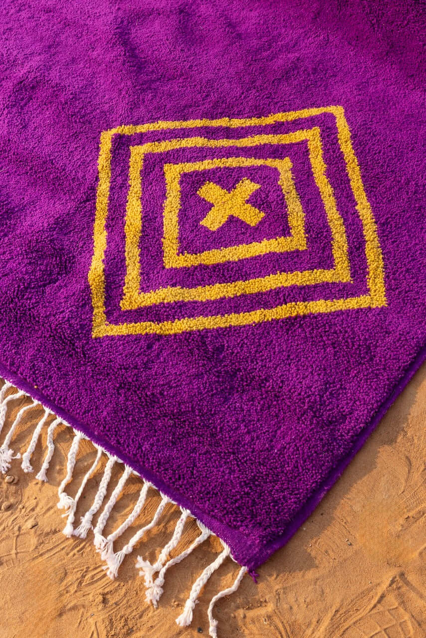 Sahara Gaze – Moroccan Rug with Golden Motifs showcasing vibrant magenta base with golden symbols.