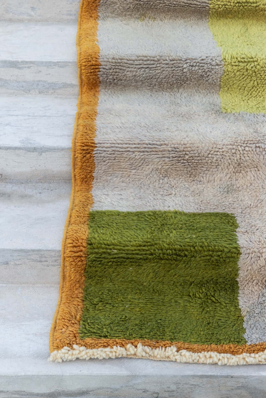 Kasbah Verde - Moroccan Rug with Geometric Blocks showcasing vibrant sage and olive tones against a warm ochre border.